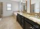 Bathroom with dual vanities, granite countertops, soaking tub, and tile flooring at 12326 Cranberry Glades Dr, Cornelius, NC 28031