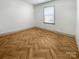 Cozy room features herringbone floors, neutral walls, window with blinds, and baseboard trim at 12326 Cranberry Glades Dr, Cornelius, NC 28031