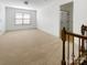 Open-concept bonus room with staircase and large window at 12326 Cranberry Glades Dr, Cornelius, NC 28031