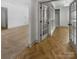 Bright hallway showcasing herringbone hardwood floors and access to closets and other rooms at 12326 Cranberry Glades Dr, Cornelius, NC 28031