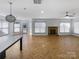 Open-concept area with a stone fireplace, chandelier, and herringbone floors, perfect for entertaining and relaxation at 12326 Cranberry Glades Dr, Cornelius, NC 28031