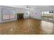 Spacious living room with neutral walls, herringbone floors, stone fireplace, and ample natural light at 12326 Cranberry Glades Dr, Cornelius, NC 28031