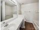 Bathroom with a large mirror, white sink, modern fixtures, and tub at 12616 Tucker Crossing Ln, Charlotte, NC 28273