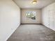 Spacious carpeted bedroom with a window offering neighborhood views and a closet at 12616 Tucker Crossing Ln, Charlotte, NC 28273