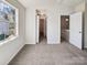 Carpeted bedroom showcasing a window, hallway access, and a view of the stairway at 12616 Tucker Crossing Ln, Charlotte, NC 28273