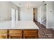 Bright kitchen view with a large island, white countertop, wooden cabinets, and double doors to the backyard at 12616 Tucker Crossing Ln, Charlotte, NC 28273