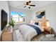 Stylish primary bedroom featuring a large window, ceiling fan, and tastefully curated decor at 13510 Tranters Creek Ln, Charlotte, NC 28273