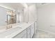 Modern bathroom vanity with double sinks, white cabinets, and a large mirror at 14030 Turncloak Dr, Charlotte, NC 28278
