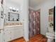 Bright bathroom featuring a single vanity, framed mirror, and a shower behind a patterned curtain at 16 Sunrise Point Ct, Lake Wylie, SC 29710