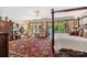 Bright bedroom showcases a grand four-poster bed, and french doors overlooking a scenic view at 16 Sunrise Point Ct, Lake Wylie, SC 29710