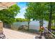 Tiled patio with metal railing overlooking a serene lake showcasing surrounding greenery and dock at 16 Sunrise Point Ct, Lake Wylie, SC 29710