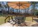 An inviting outdoor dining set under an umbrella is ideal for entertaining at 1661 California Rd, York, SC 29745