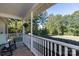 Cozy front porch featuring a rocking chair, hanging flowers, and a serene view of the surrounding greenery at 1661 California Rd, York, SC 29745