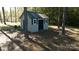 Well-maintained storage shed nestled among the trees in the backyard of the property at 1661 California Rd, York, SC 29745