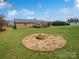 A lush backyard features a fire pit, green grass, and the back of the house at 189 Beech Brook Ln, Statesville, NC 28625