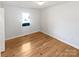 Bright bedroom features hardwood floors, white walls, trim, and a window for natural light at 189 Beech Brook Ln, Statesville, NC 28625