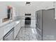 Modern kitchen with white cabinets, stainless steel appliances, and marble-look tile flooring at 189 Beech Brook Ln, Statesville, NC 28625