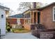 View of a backyard featuring a brick house with outdoor grill area and charming covered porch with string lights at 1937 Wilmore Dr, Charlotte, NC 28203