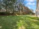 Expansive backyard with lush green lawn, mature trees and a wooden playset at 2100 Bluebonnet Ln, Matthews, NC 28104