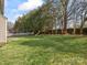 Spacious backyard featuring lush green grass, mature trees, a white picket fence, and a wooden swing set at 2100 Bluebonnet Ln, Matthews, NC 28104