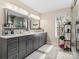 Bright bathroom featuring double vanity with gray cabinets, white marble countertop and modern lighting at 2100 Bluebonnet Ln, Matthews, NC 28104