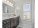 Well-lit bathroom featuring a dark vanity cabinet with marble countertop and white walls at 2100 Bluebonnet Ln, Matthews, NC 28104