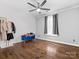 Minimalist bedroom with hardwood floors, ceiling fan and a comfortable blue bench near window at 2100 Bluebonnet Ln, Matthews, NC 28104