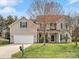 Charming two-story home with a well-manicured lawn and mature landscaping at 2100 Bluebonnet Ln, Matthews, NC 28104