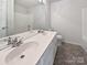 Bathroom with double sinks, a large mirror, and a shower-tub combo at 21005 Brinkley St, Cornelius, NC 28031
