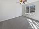 A well-lit bedroom includes a ceiling fan, a window and neutral walls and carpet at 21005 Brinkley St, Cornelius, NC 28031