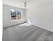 A bright bedroom featuring neutral walls, carpet, and a large window offering natural light at 21005 Brinkley St, Cornelius, NC 28031