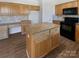 The kitchen features wood cabinets, black appliances, an island, and stone backsplash at 21005 Brinkley St, Cornelius, NC 28031