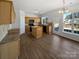 Open kitchen with wood cabinets, black appliances, an island, and hardwood style floors at 21005 Brinkley St, Cornelius, NC 28031
