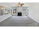 This is a spacious living room featuring a fireplace, multiple windows and a ceiling fan at 21005 Brinkley St, Cornelius, NC 28031