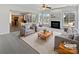 Bright living room boasts a fireplace, large windows, and view to the open concept kitchen at 21005 Brinkley St, Cornelius, NC 28031