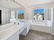 A bright primary bath includes dual sinks, a soaking tub, and a glass-enclosed shower at 21005 Brinkley St, Cornelius, NC 28031