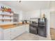 Well-lit kitchen with white cabinets, wood countertops, black appliances, and tile floors at 2320 Monterey Park Dr, Gastonia, NC 28054