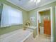 Bathroom featuring jacuzzi tub, shower, window, and adjacent closet at 2615 High Ridge Church Rd, Marshville, NC 28103