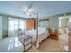Inviting bedroom with a four-poster bed, ceiling fan, rocking crib and light green walls at 2615 High Ridge Church Rd, Marshville, NC 28103