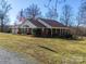 Ranch style brick home with covered front porch, mature landscaping, and American flag at 2615 High Ridge Church Rd, Marshville, NC 28103