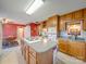 View of kitchen island with cooktop and wood cabinetry and adjacent breakfast area with colorful rug and red walls at 2615 High Ridge Church Rd, Marshville, NC 28103