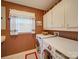 Functional laundry room with front-loading washer and dryer, white cabinets, and a small window at 2615 High Ridge Church Rd, Marshville, NC 28103