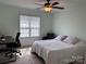Bright bedroom features a ceiling fan, large window, and space for a desk and sitting area at 321 Creek Se Trl, Concord, NC 28025