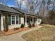 Charming single-story home featuring a welcoming front porch and landscaped yard with mature trees at 321 Creek Se Trl, Concord, NC 28025