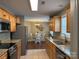 Spacious kitchen featuring granite countertops, wooden cabinets, and stainless steel appliances, open to dining area at 321 Creek Se Trl, Concord, NC 28025
