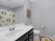 Well-lit bathroom featuring a spacious vanity with a dark wood cabinet and decorative shower curtain at 3230 Yarmouth Ln, Gastonia, NC 28056
