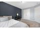 This bedroom features a dark accent wall, neutral carpet, and a vanity with a mirror and chair at 3230 Yarmouth Ln, Gastonia, NC 28056