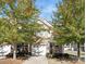 A well-maintained two-story townhome features a brick facade and attached garage, framed by lush, mature trees at 3230 Yarmouth Ln, Gastonia, NC 28056