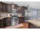 Modern kitchen with stainless steel appliances, dark cabinetry, granite countertops, and tile backsplash at 3230 Yarmouth Ln, Gastonia, NC 28056