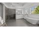 Modern bathroom featuring a walk-in shower, soaking tub, and double vanity with a large window at 343 Belton St, Charlotte, NC 28209